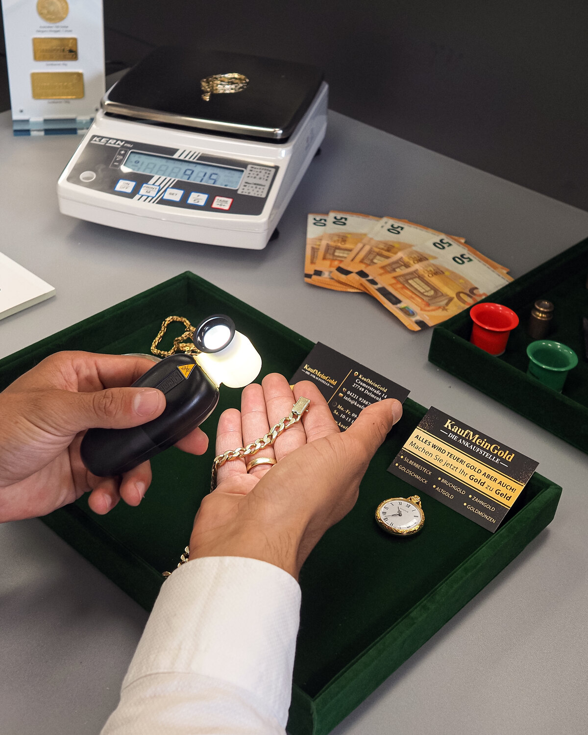 Goldkette und Taschenuhr auf der Präzisionswaage